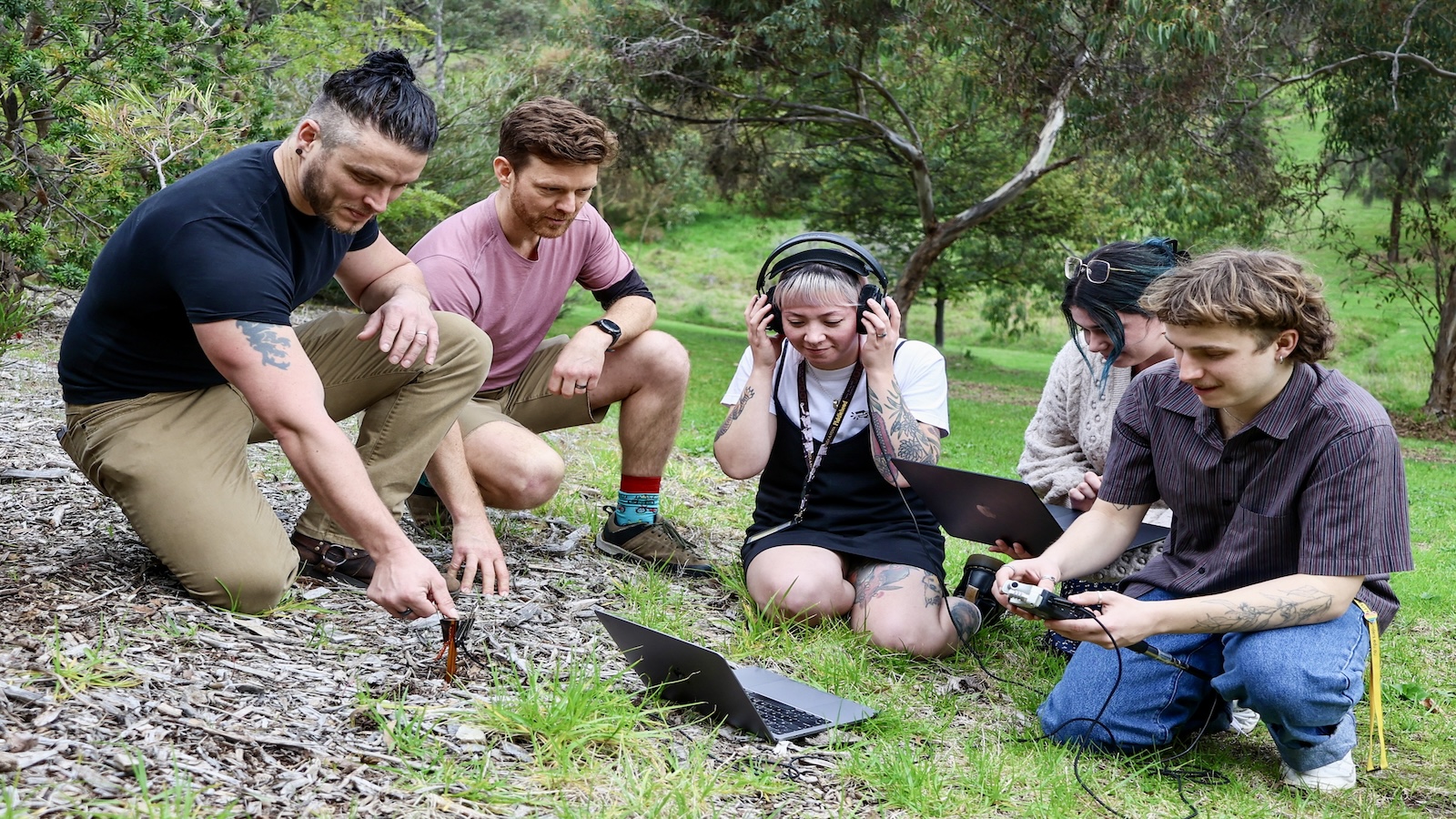 A group of people sit in the soil