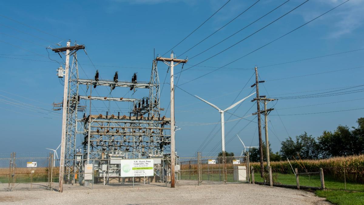 An electrical station with a wind turbine next to it