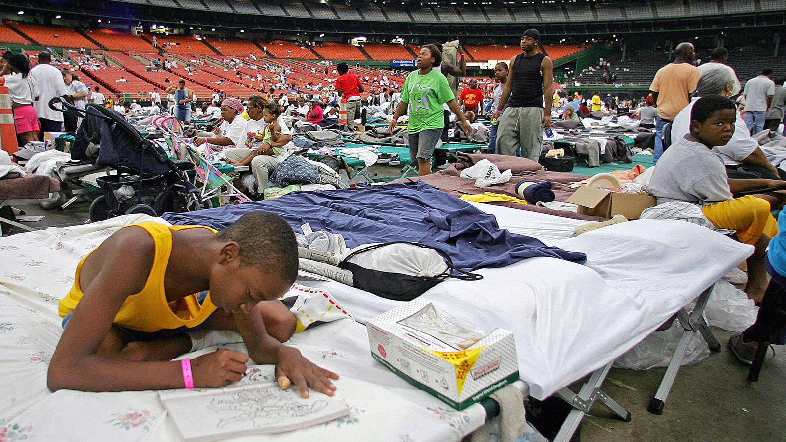 A Katrina evacuee passes the time coloring a book inside the Houston Astrodome on September 3, 2005