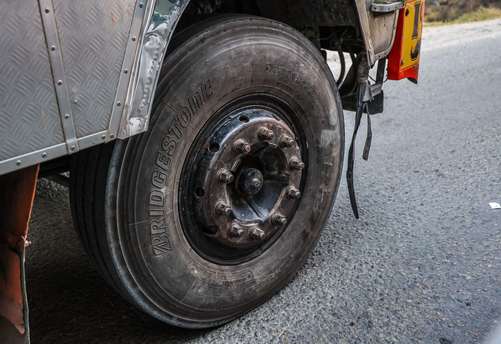 Closeup of a worn black tire, with the word "Bridgestone" written on it.