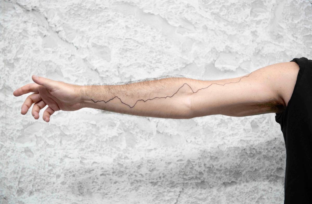 A photo of an outstretched arm with a line diagram tattooed from wrist to shoulder