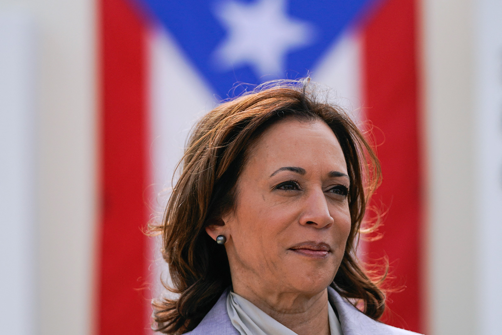 US Vice President Kamala Harris is seen with the flag of Puerto Rico in the background