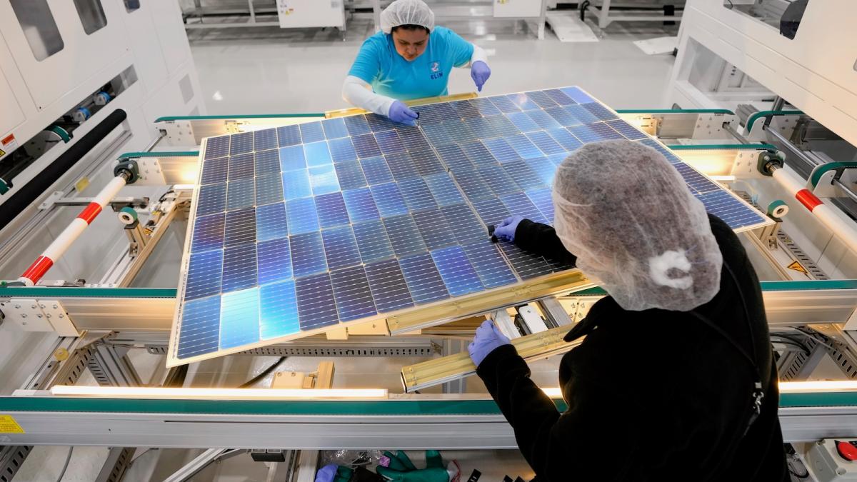 Two women assemble a photovoltaic solar panel in a factory in Texas