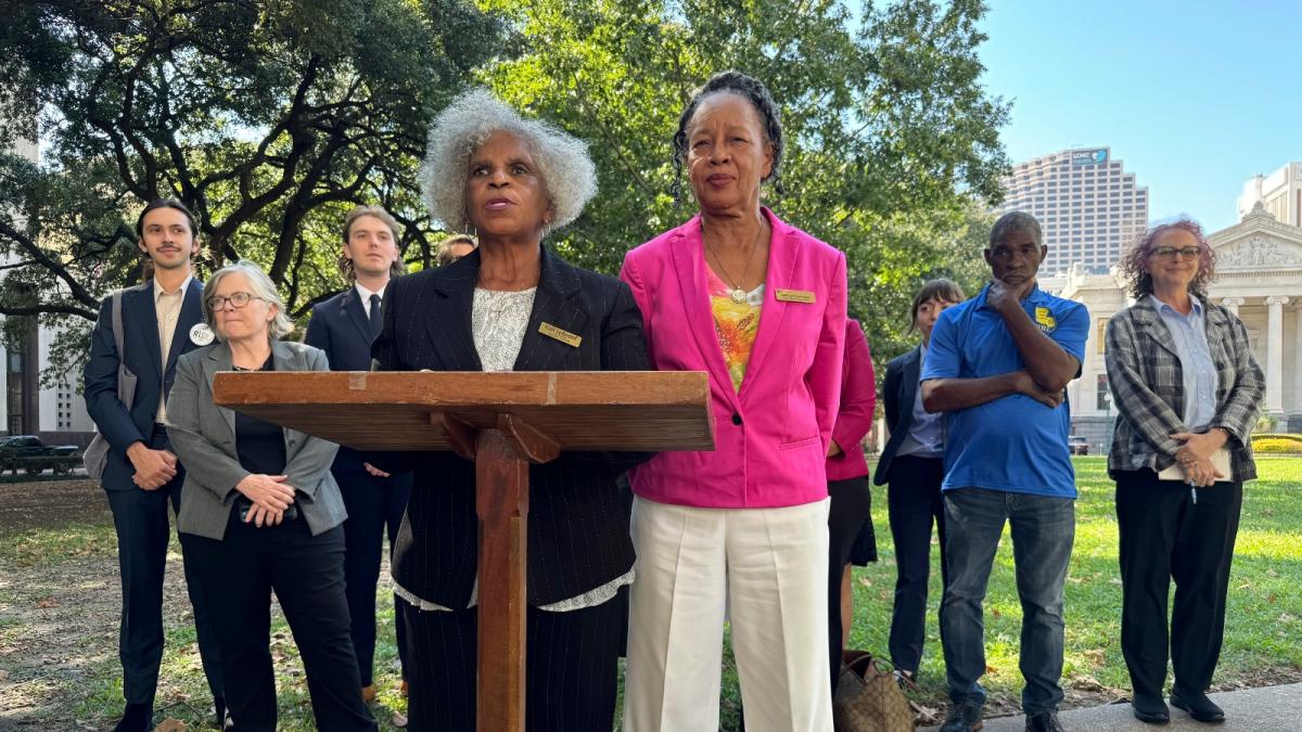 A group of people stand at a lectern during a press conference in St. James, Louisiana