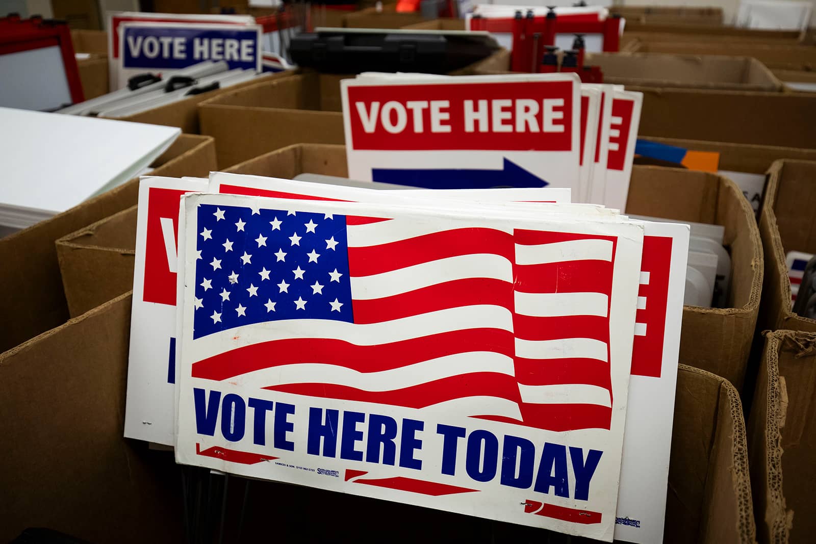 Cardboard boxes containing red and blue voting signs